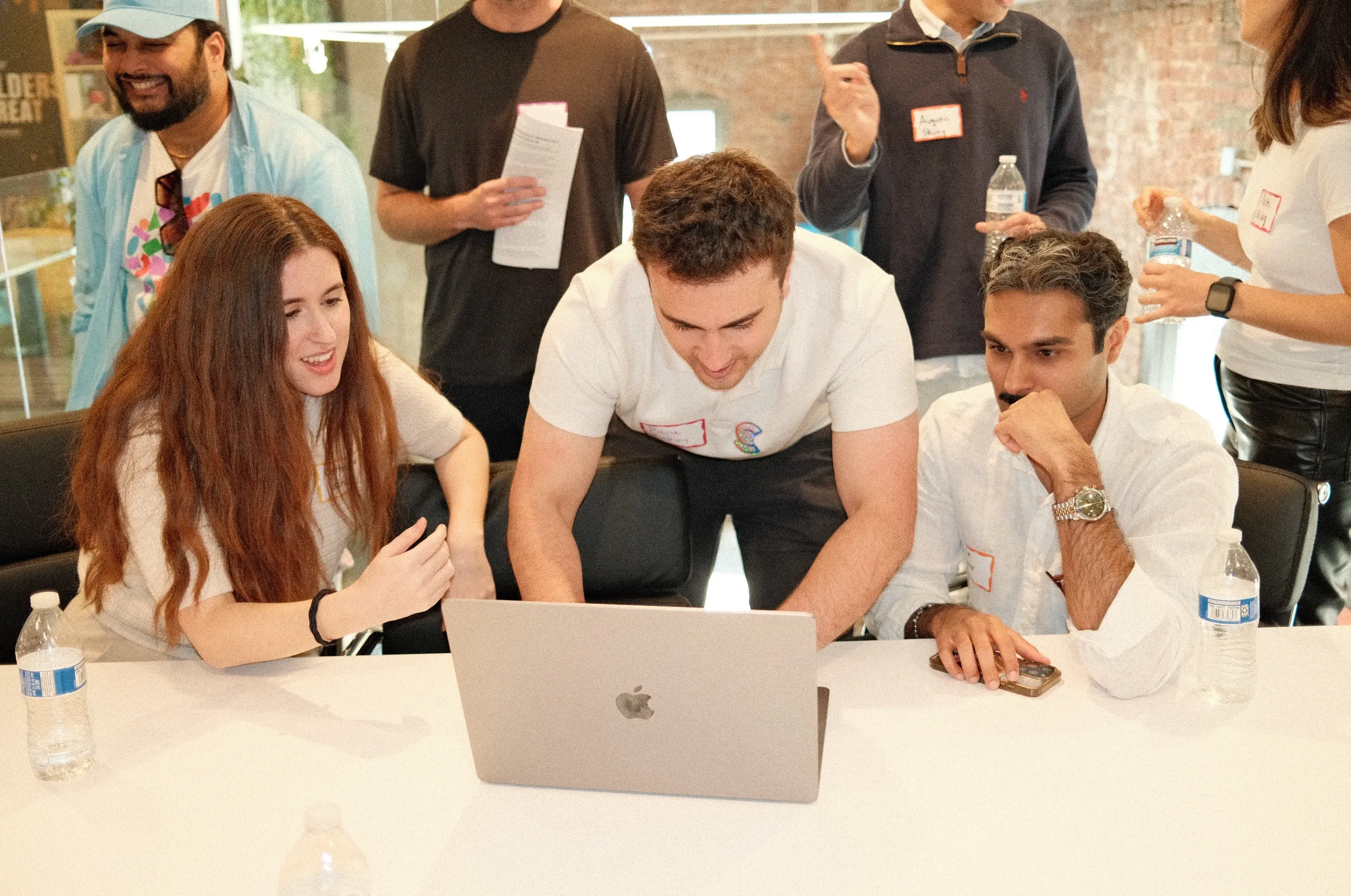 Catherine collaborating with a group around a laptop